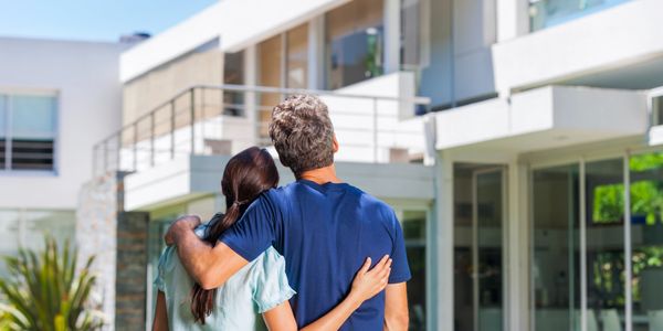 a couple staring at a house