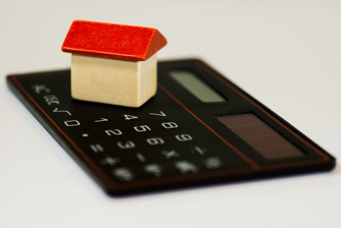 picture of tiny wooden toy house and calculator 