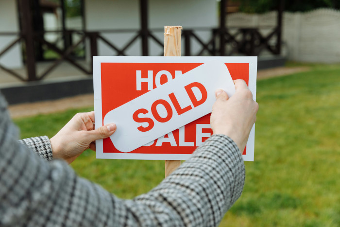 a sign for sale being turned into sold