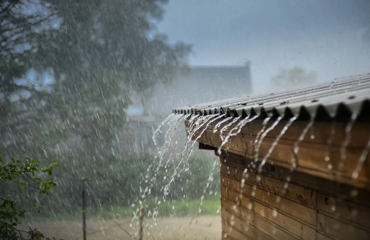 a house roof overflowing with rain