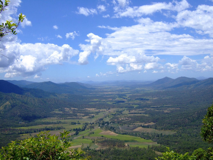 a view of a town that is surrounded by small green mountains