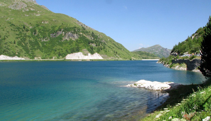 a blue lake area with large green cliffs and mountains