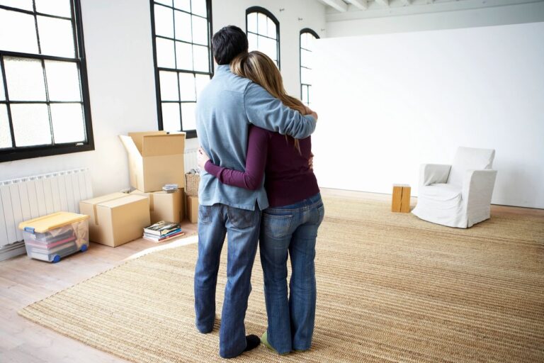 a couple hugging in a home that has been packed for moving