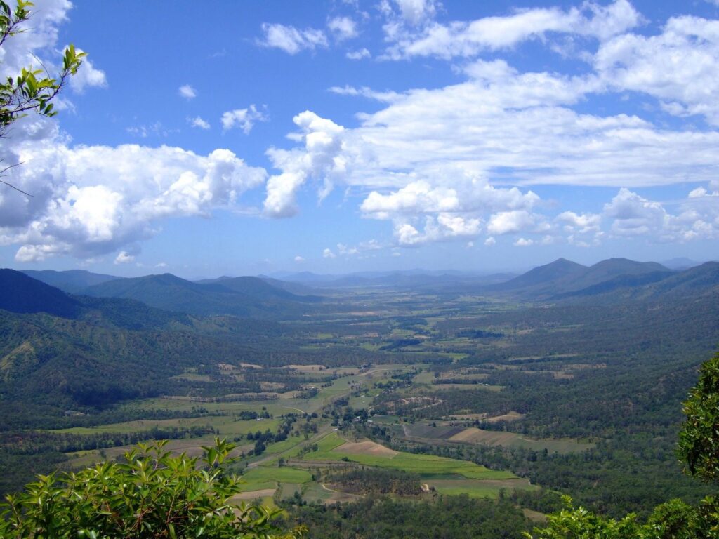 view of a town surrounded by green small mountains and hills