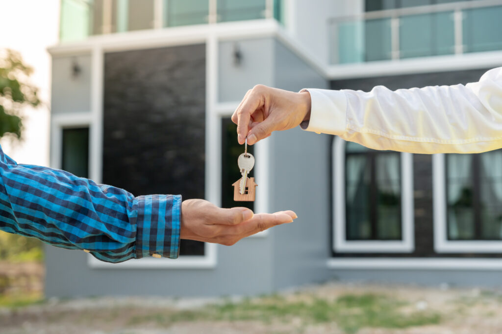 buyers agent handing house key to new owner.