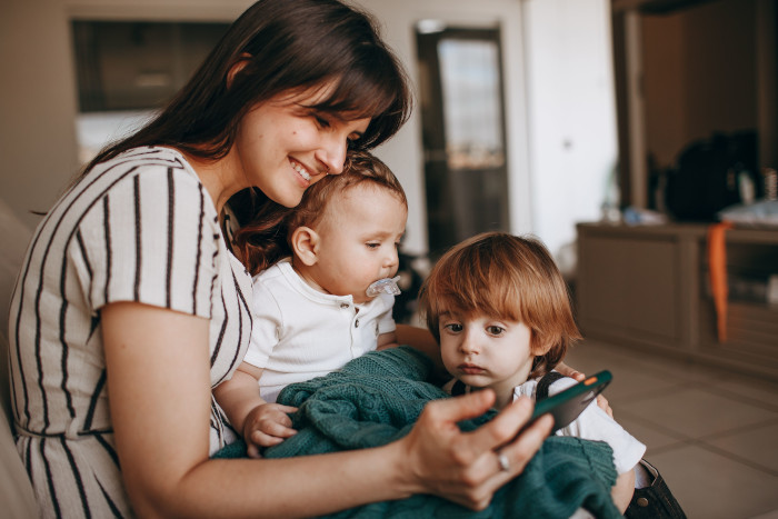 mother and two young children enjoying time indoors together.
